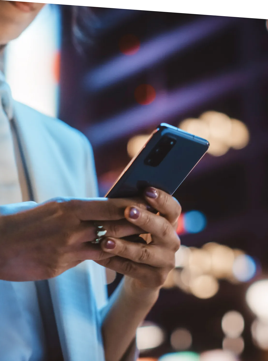 Female holding a smartphone in her hands.