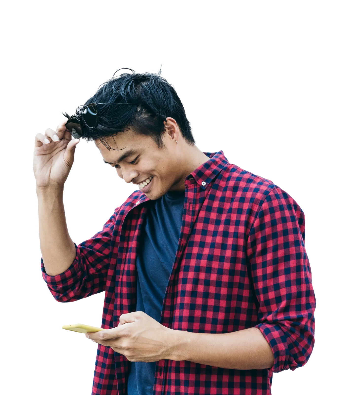 A young man smiling and having fun scrolling through his smartphone.