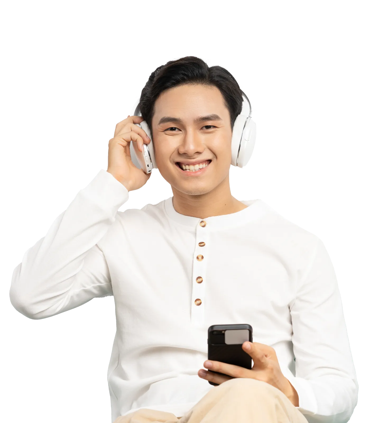 A young man smiling and wearing wireless headphones with his smartphone in his hands.
